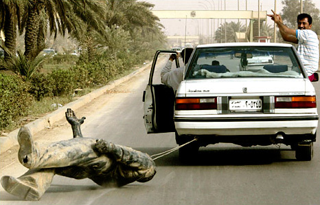 Celebrating Iraqis dragged a statue of Saddam Hussein that was pulled from its pedestal, Baghdad, April 9, 2003.